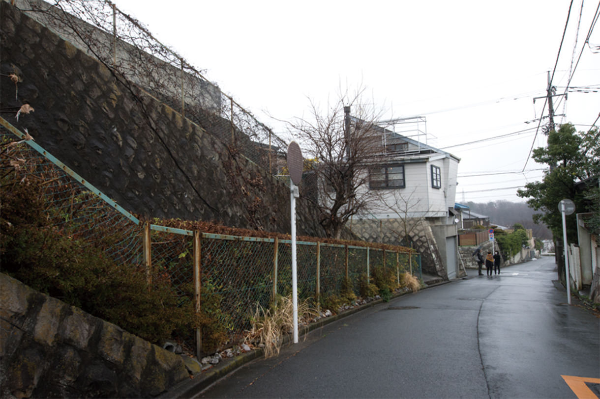 左手の石垣の上が昔からの墓地。 写真／普後 均