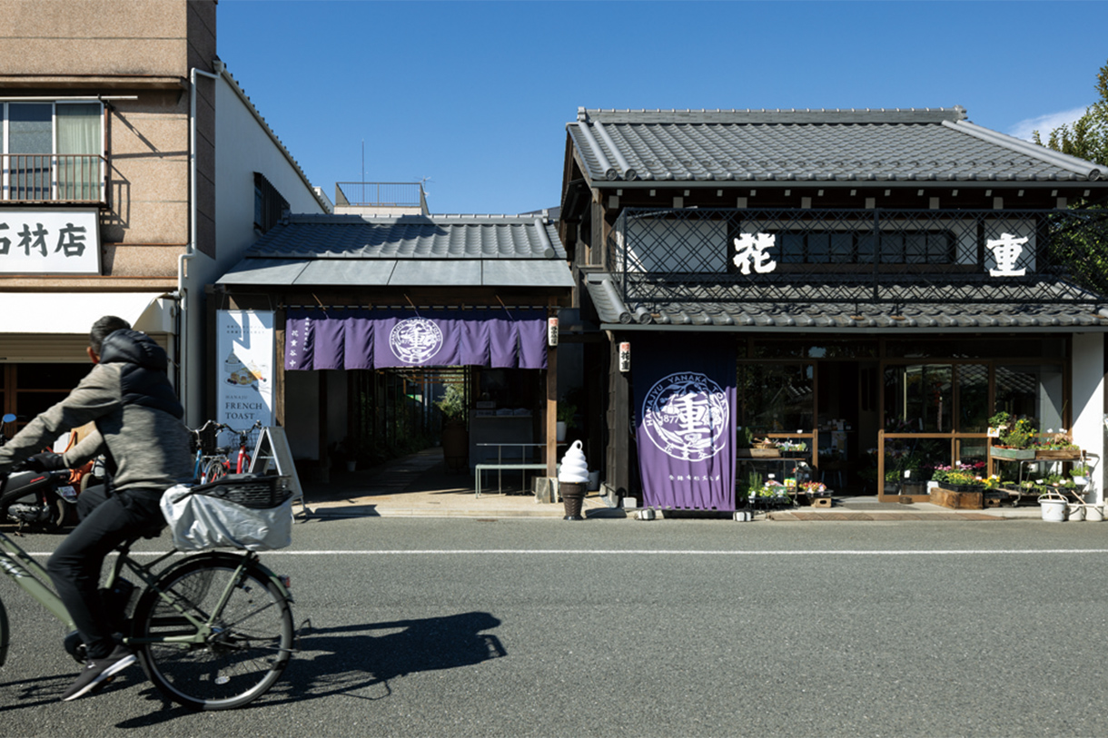 右が花屋（明治棟）で、左の暖簾をくぐると裏手にカフェと庭。 写真／藤塚光政