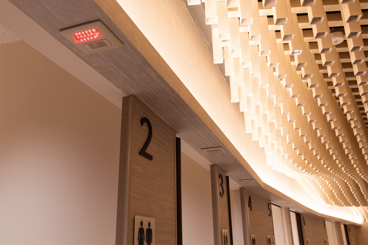 紙の筒がうねる天井 非常灯 個室内の非常呼出ボタンを押すと、扉前の非常灯が点灯する。写真/傍島利浩