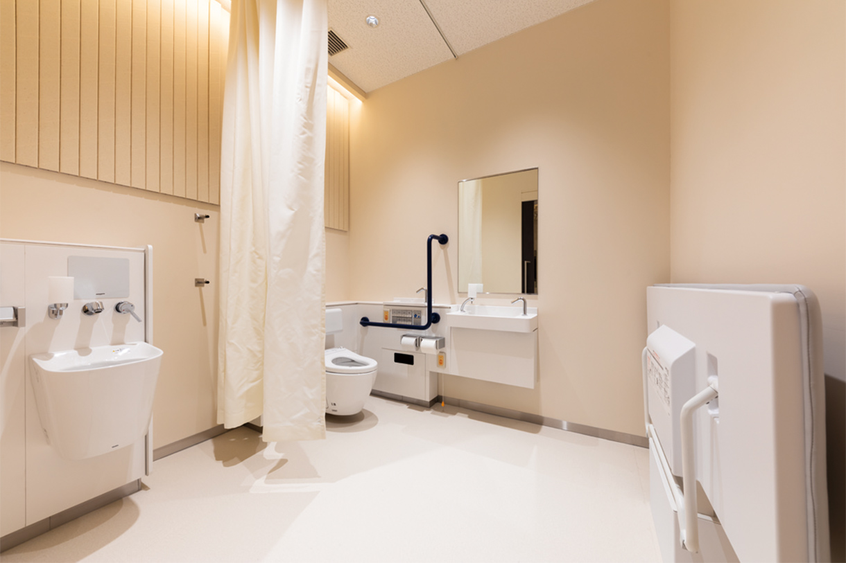 紙の筒がうねる天井 車いす対応トイレ 介助用ベッドやオストメイトパックなどがある。写真/傍島利浩