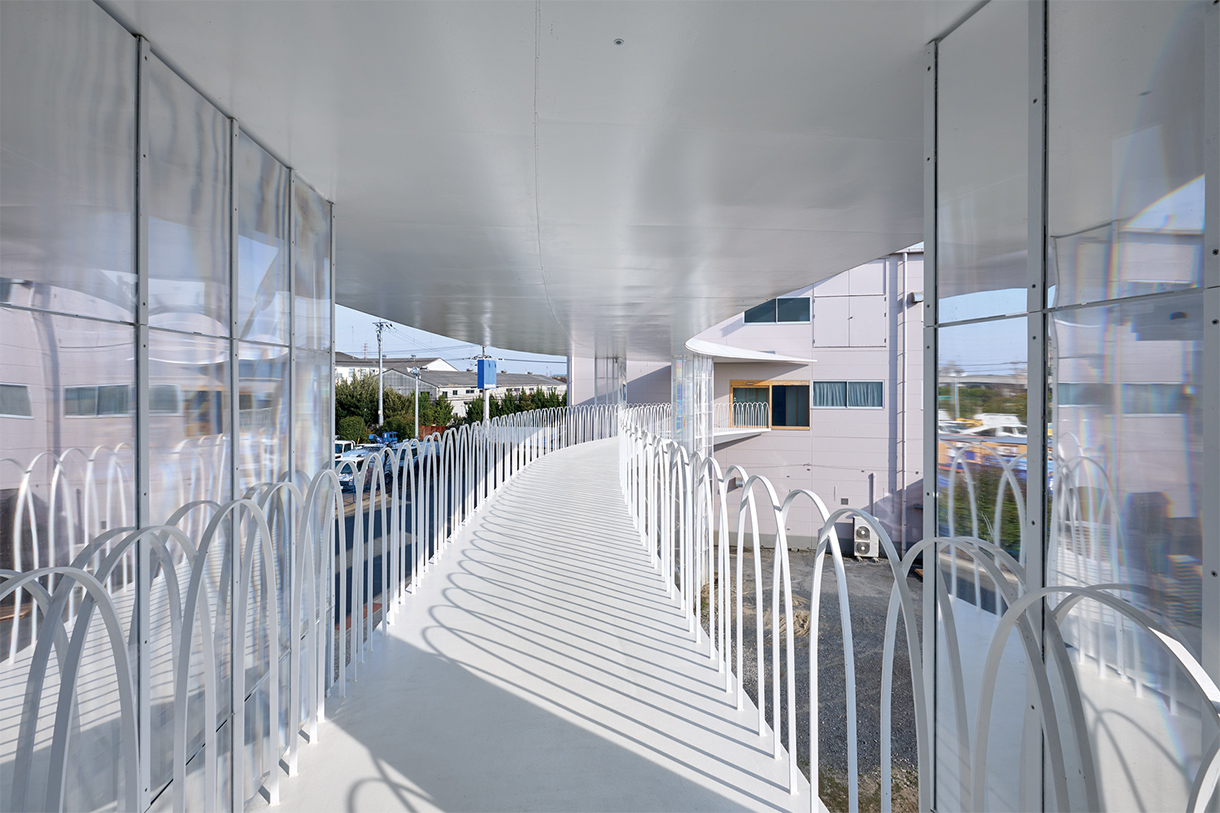 歩廊から第一工場を見る。公園から着想を得たという手すりは、フラットバーを曲げて製作。写真/川辺明伸